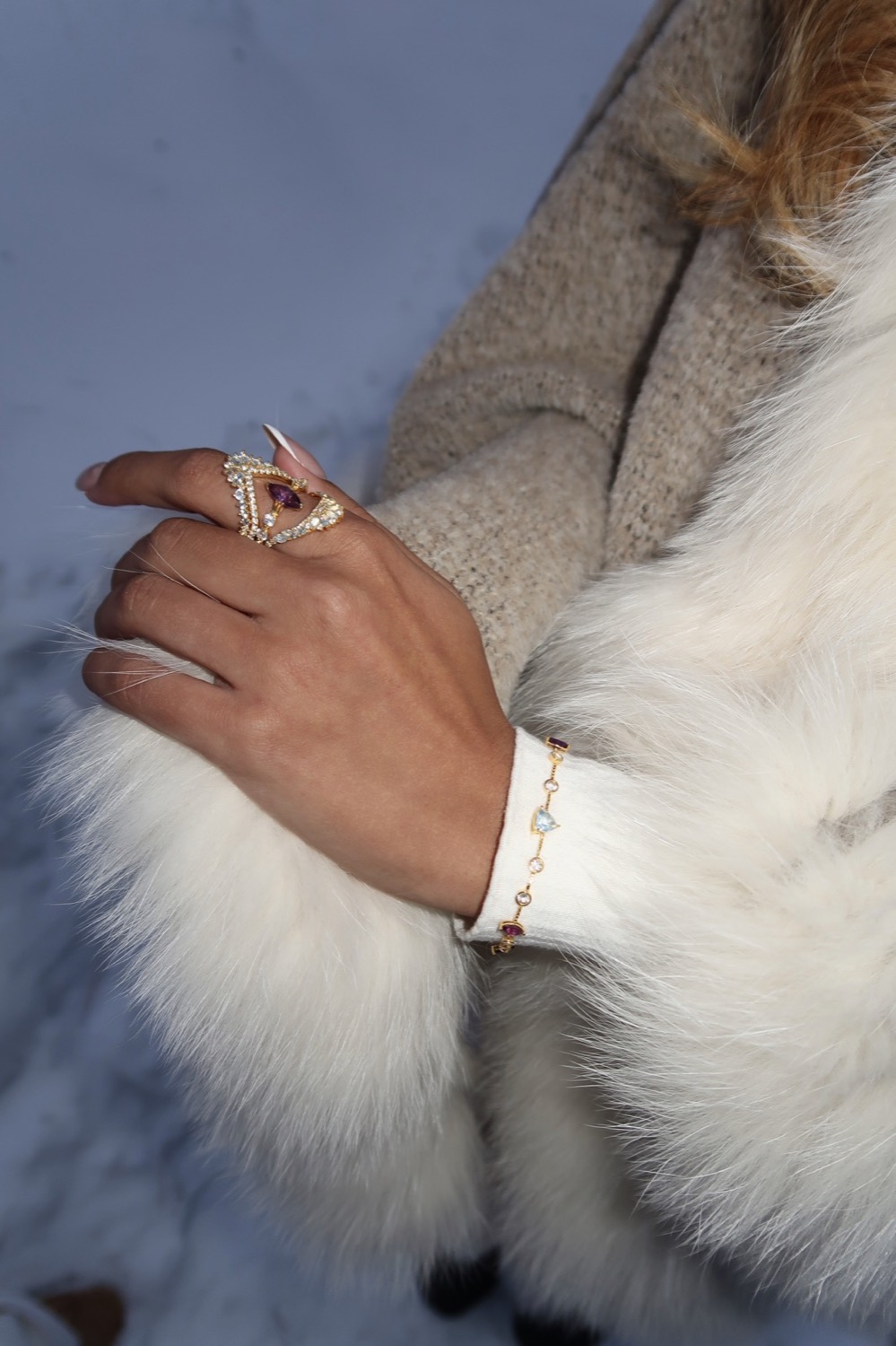 Close-up of model wearing rings and bracelet